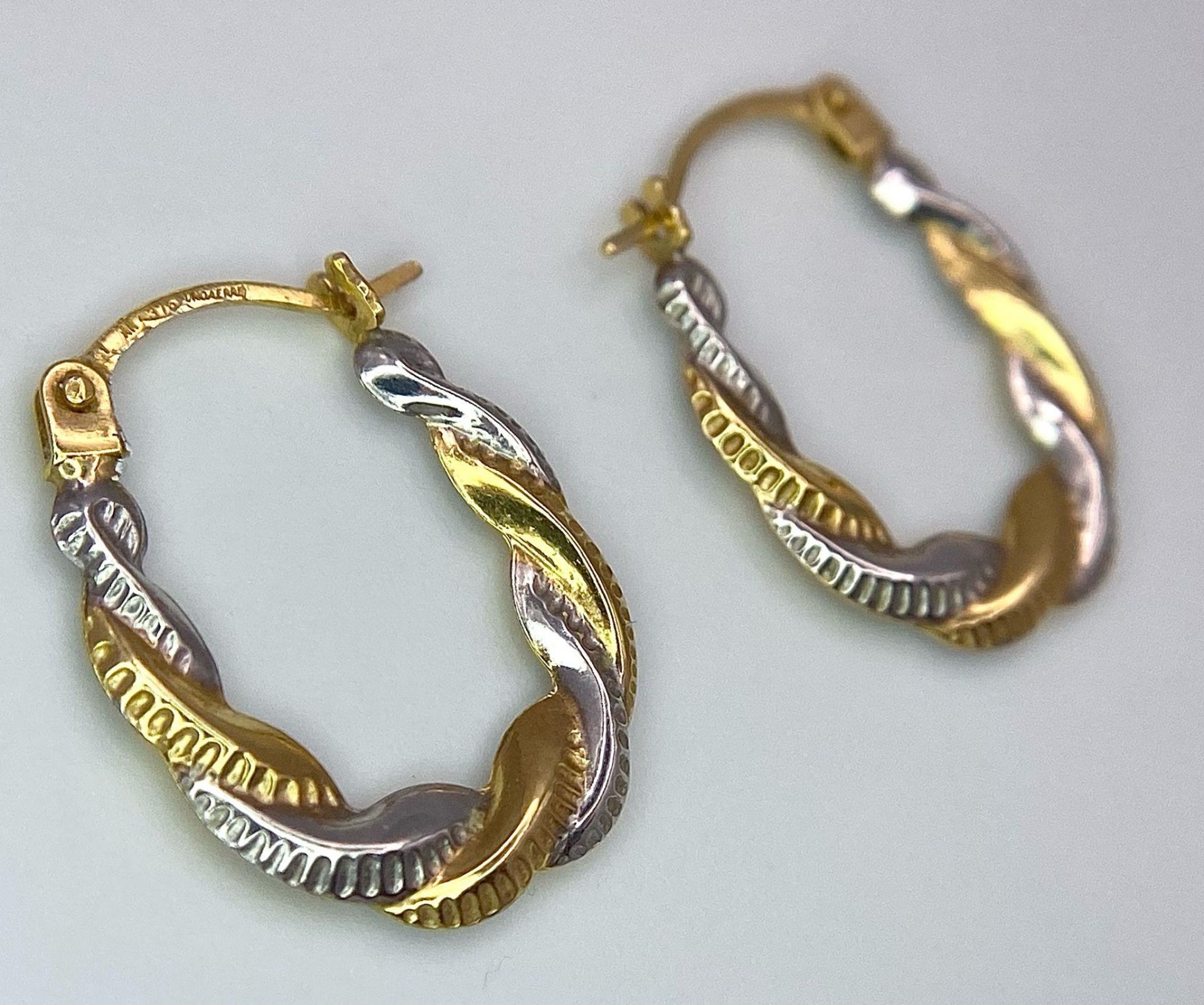 A Pair of 9K Bi-Colour Gold Oval Hoop Twist Earrings. 0.44g weight.