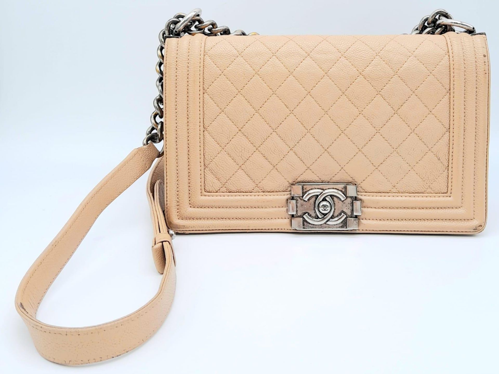 A Chanel Beige Boy Bag. Leather exterior with silver-toned hardware, chain and leather adjustable