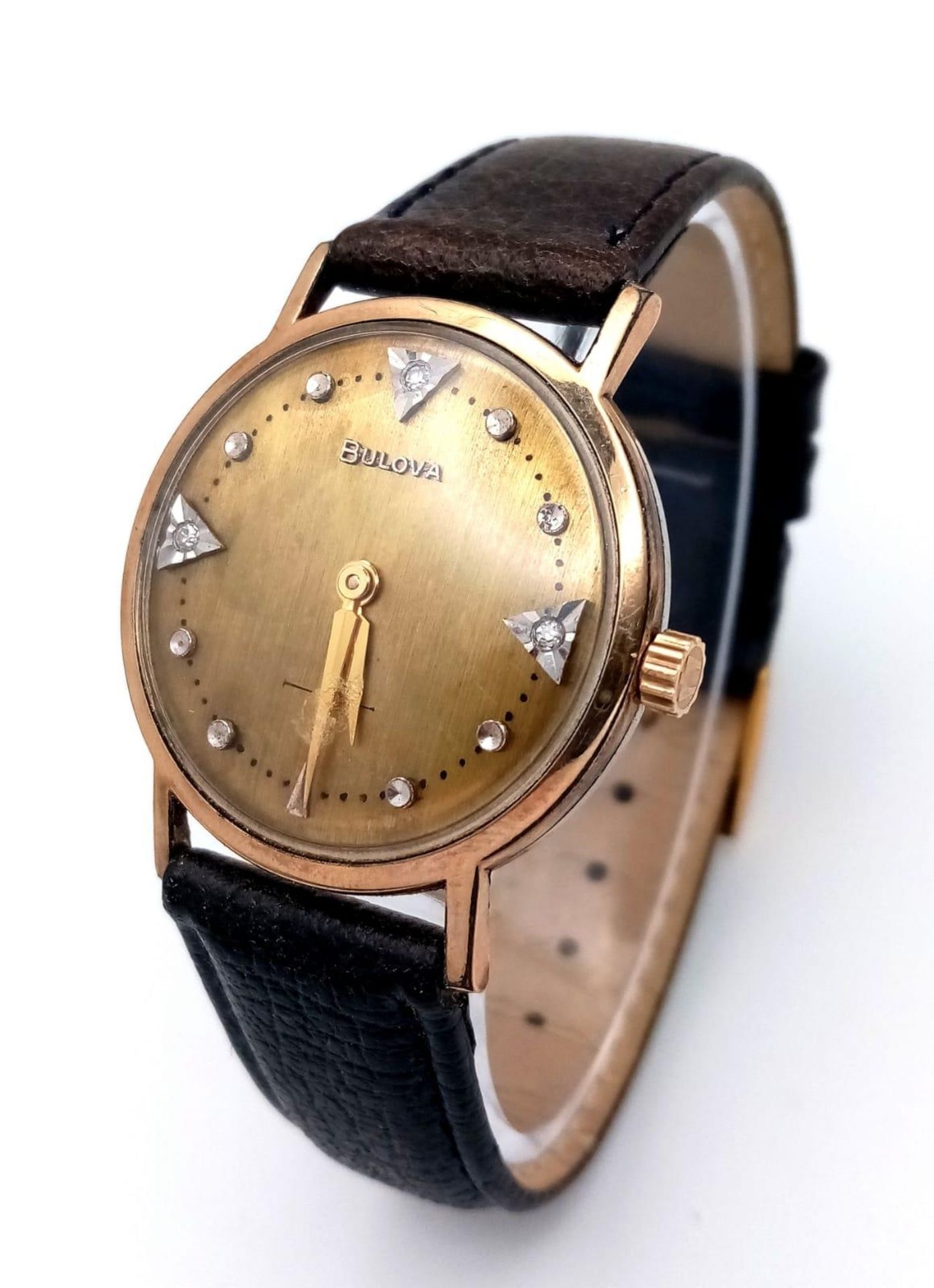 A BULOVA MID SIZE GOLD PLATED MANUAL WIND WATCH WITH DIAMOND NUMERALS AND GOLD TONE DIAL . 32mm