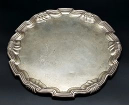 An Antique Sterling Silver Salver with a Decorative scrolled edge. 31cm diameter. 606g weight.