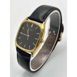 A gold plated, steel SEIKO watch, case: 32 x 29 mm, black dial with gold coloured hour marks and