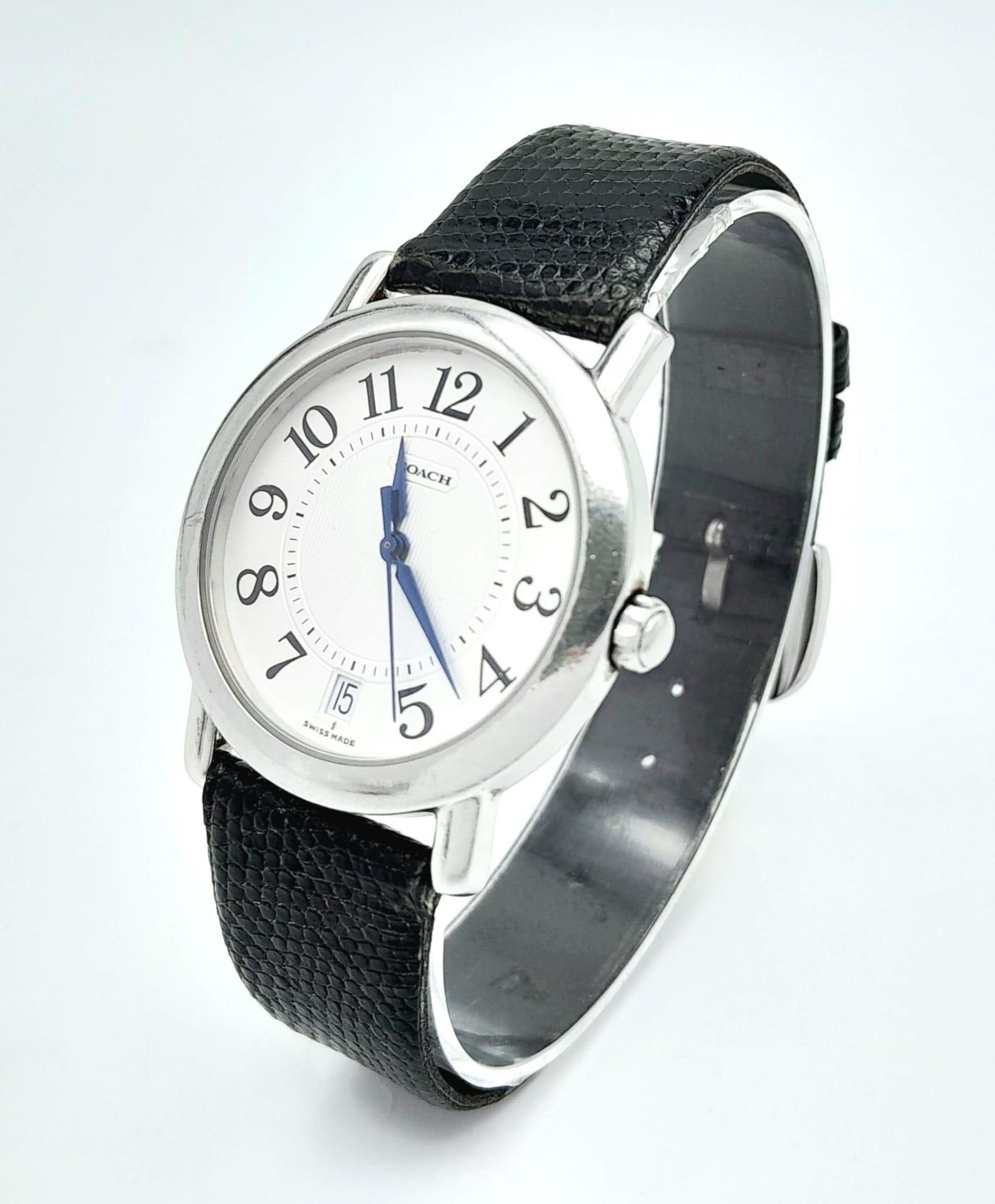 A Coach Quartz Gents Watch. Black leather strap. Stainless steel case. White dial. In working order.