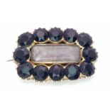 An Antique Mid Karat Gold and Sapphire Memorial Brooch/Pendant. 12 round cut sapphires. 25mm x 17mm.