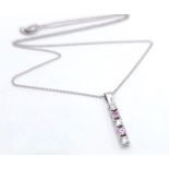 An 18 K white gold drop pendant with diamonds and pink sapphires (rubies) on an 18 K white gold