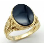A 9 k yellow gold fancy cygnet ring with an oval cut black onyx, size: W, weight: 5.4 g.
