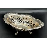 A vintage sterling silver bonbon dish with scrolled feet and pierced floral patterns. Total weight