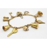 A 9K GOLD CHARM BRACELET WITH 9 CHARMS TO INCLUDE A TANKARD, KETTLE ,KEY TO THE DOOR AMND MANY