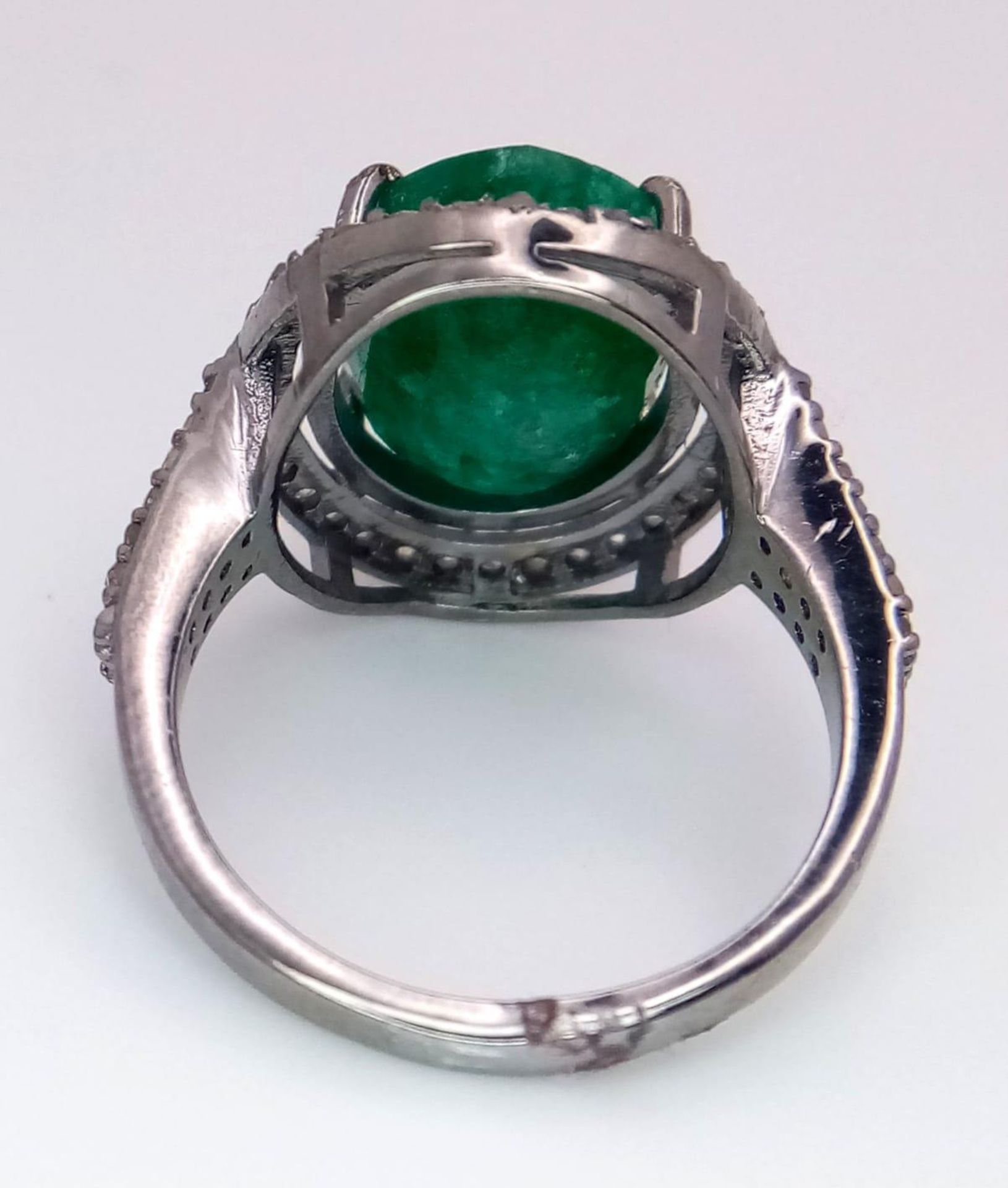 An Emerald Ring with a Halo of Diamonds on 925 Silver. 7.55ct emerald, 0.67ctw diamonds. Size N, 4. - Image 5 of 6