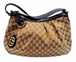 A Gucci Brown Monogram Suki Shoulder Bag. Pleated canvas exterior with leather trim and strap,