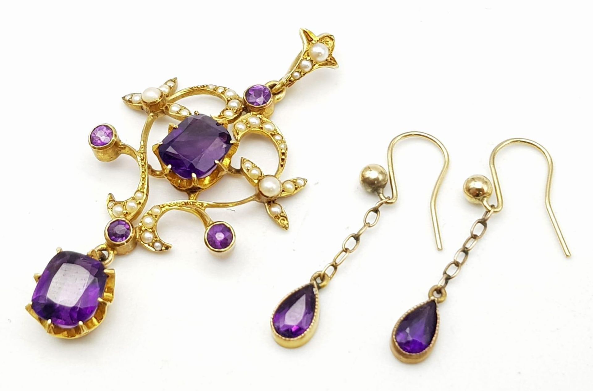 An ART NOUVEAU 9 K yellow gold pendant with vivid coloured amethysts and natural seed pearls,