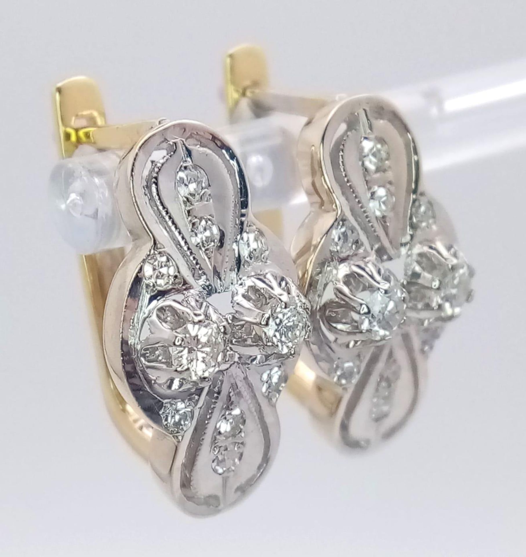An 18 K white and yellow gold pair of earrings with a nice, diamond set design, length: 21 mm, - Bild 5 aus 6