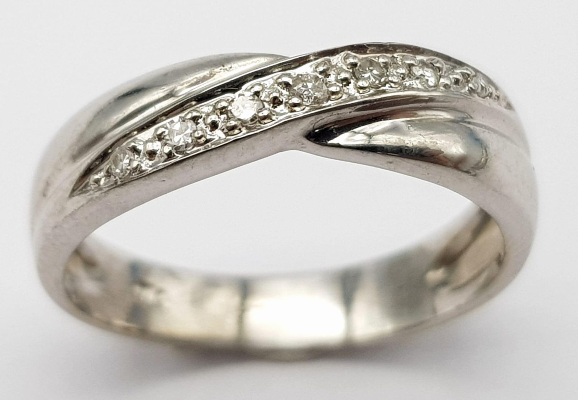 A 9K white Gold (tested) Diamond Twist Ring. 0.05ct diamond. Size K. 2.4g total weight. - Image 2 of 5