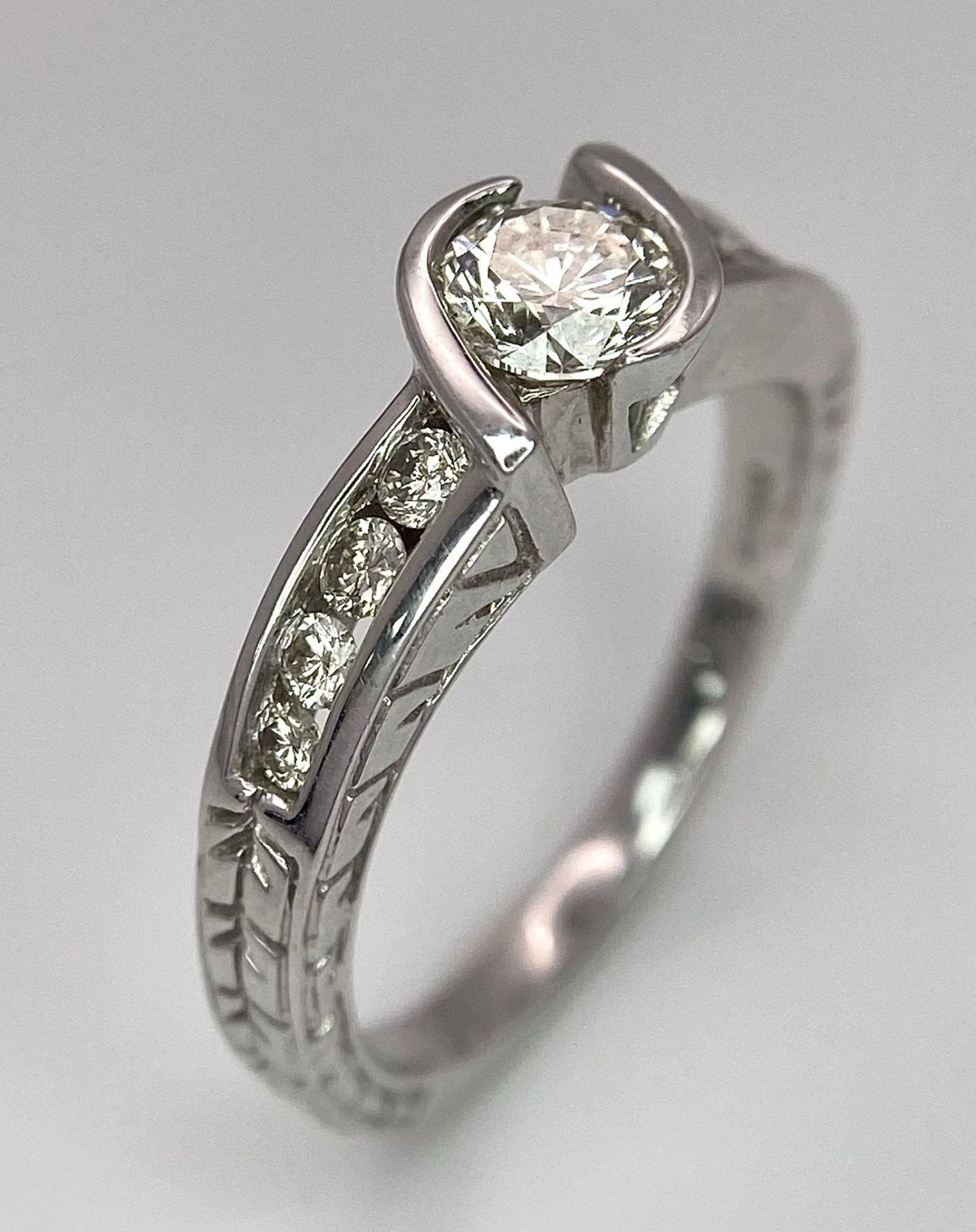 An 18K White Gold Diamond Crossover Ring. 0.50ct tinted brilliant round cut diamond with eight round - Image 5 of 9