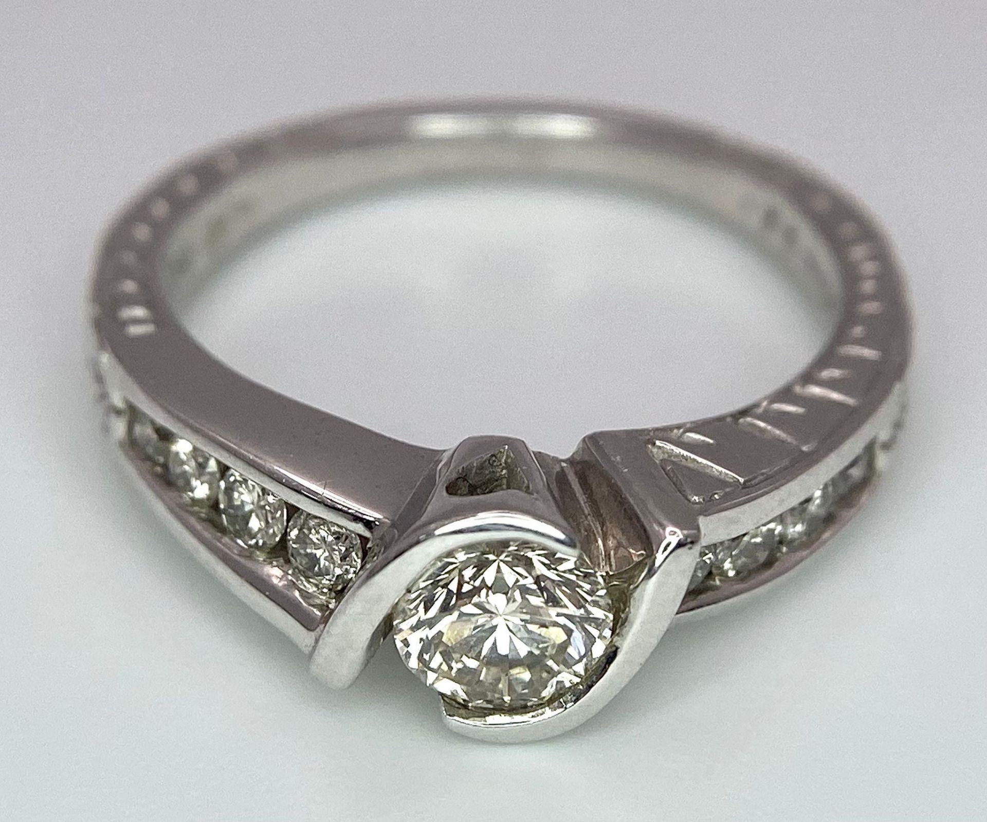 An 18K White Gold Diamond Crossover Ring. 0.50ct tinted brilliant round cut diamond with eight round - Image 6 of 9