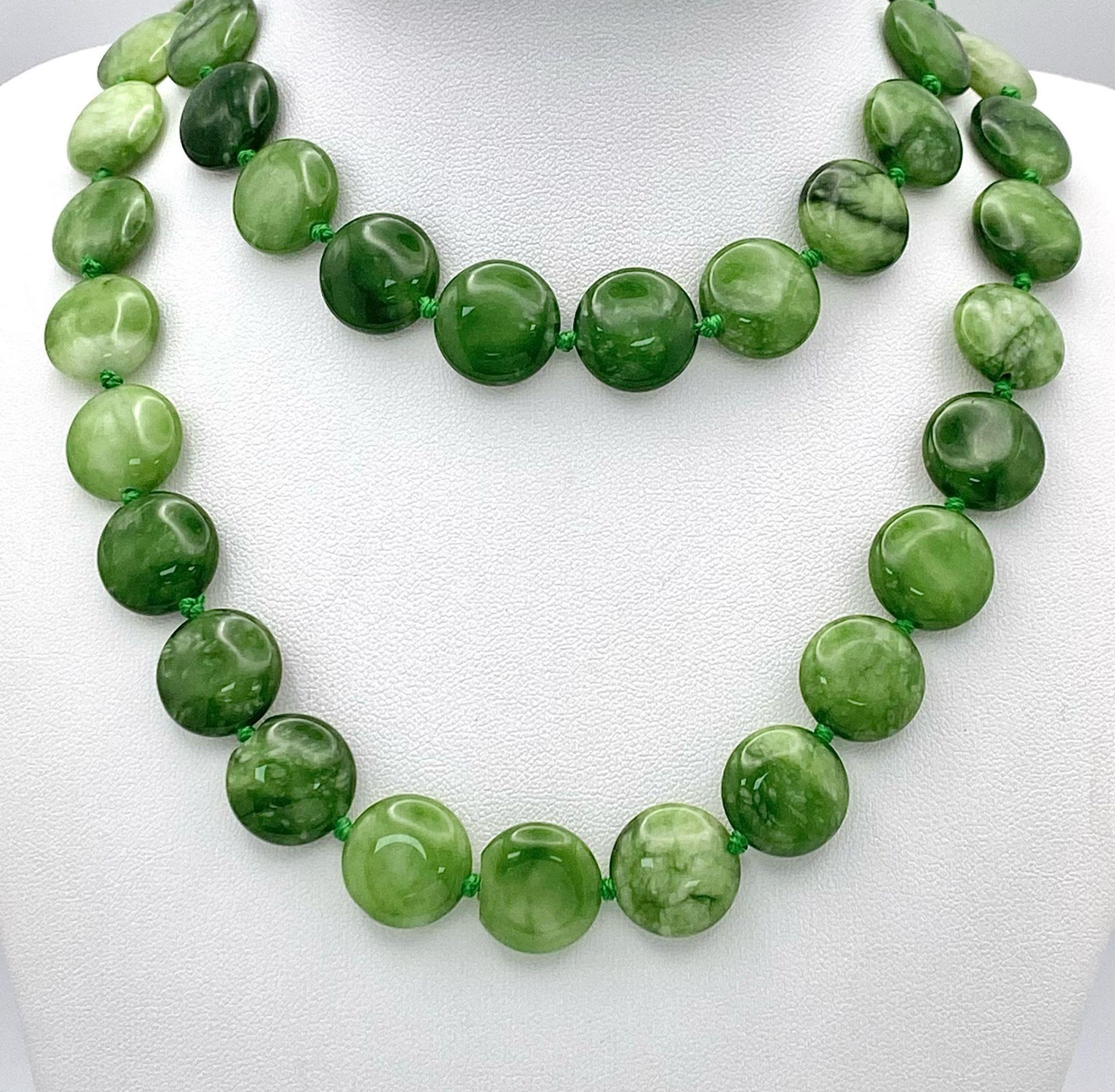 A Green and White Jade Coin Bead Necklace. 14mm beads. 68cm length.