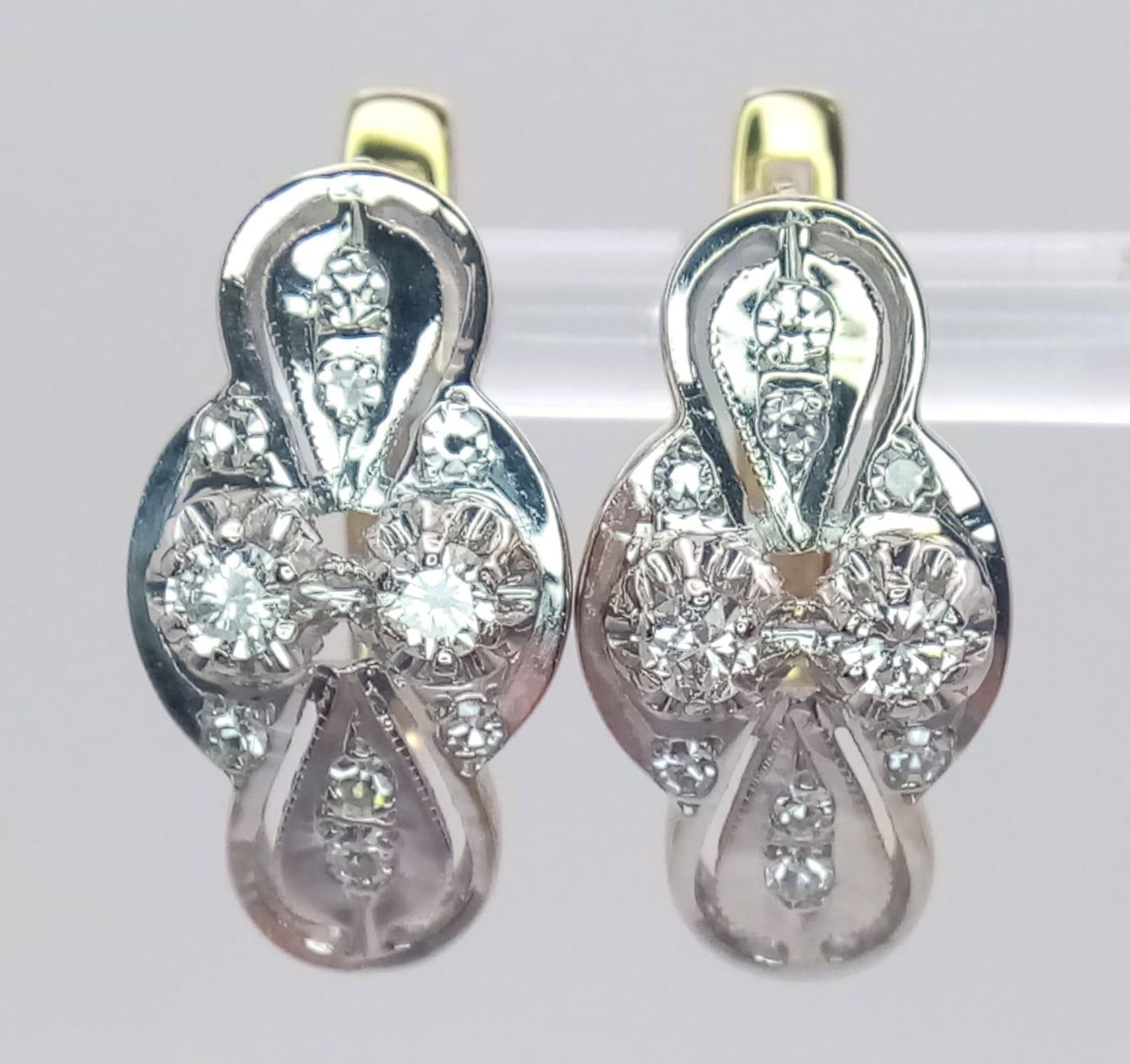 An 18 K white and yellow gold pair of earrings with a nice, diamond set design, length: 21 mm, - Bild 4 aus 6