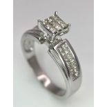 A 14K White Gold Diamond Ring. Nine small central squares with diamond squares on shoulders. 0.