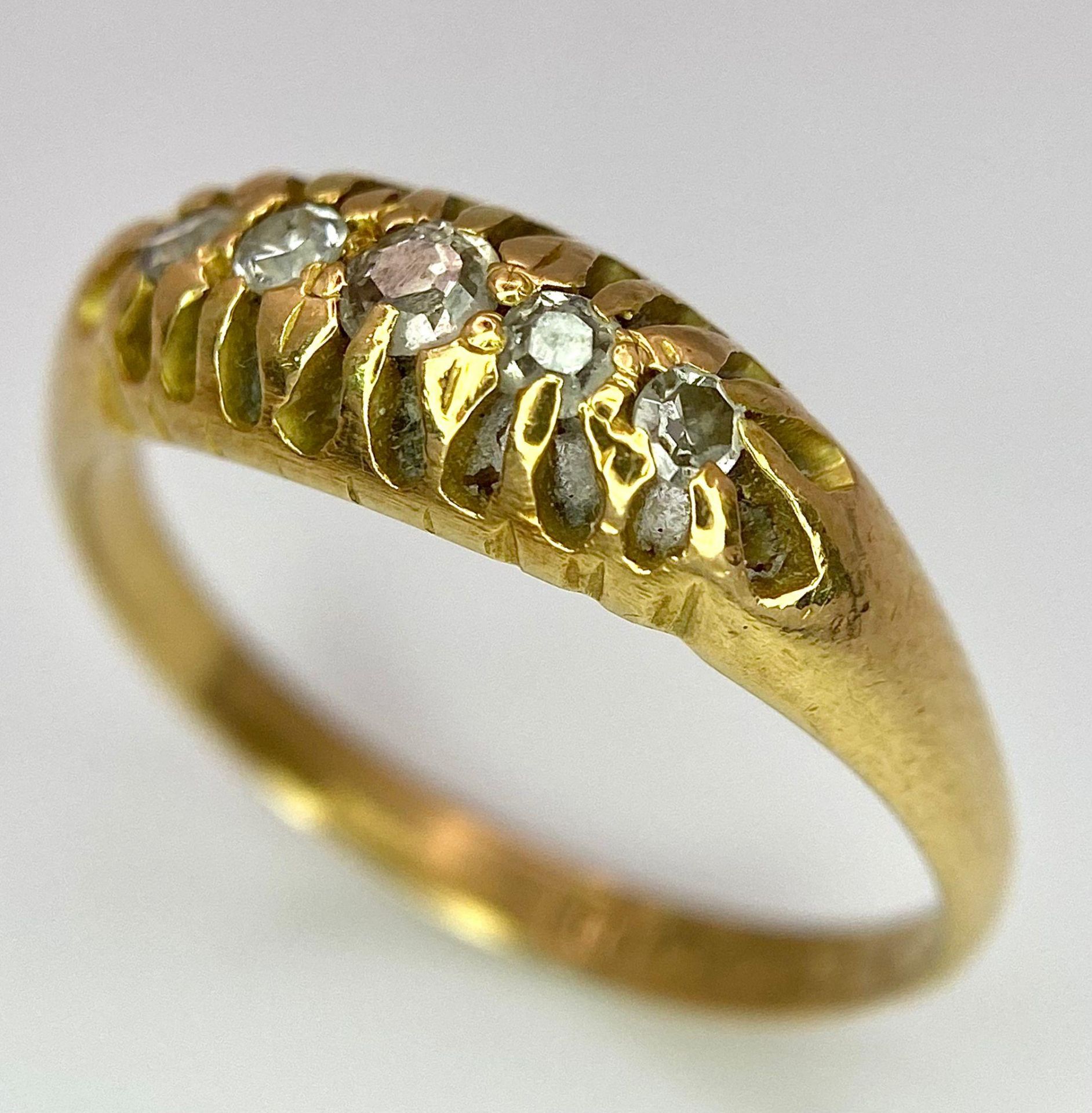 An 18 K yellow gold ring with a band of five diamonds, size: O, weight: 3.2 g.