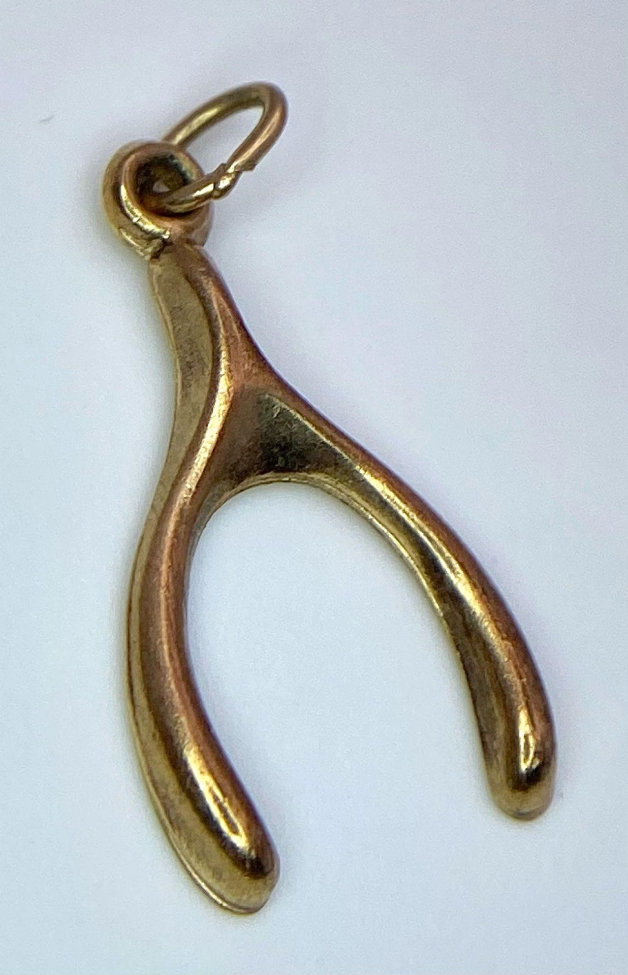 A 9K YELLOW GOLD WISHBONE CHARM. TOTAL WEIGHT 0.4G