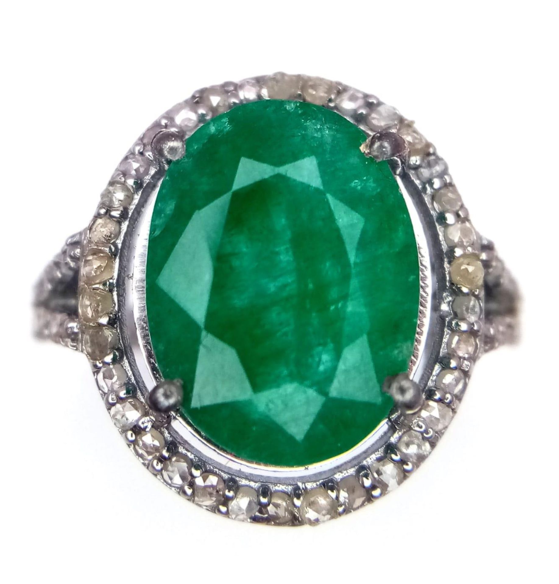 An Emerald Ring with a Halo of Diamonds on 925 Silver. 7.55ct emerald, 0.67ctw diamonds. Size N, 4.