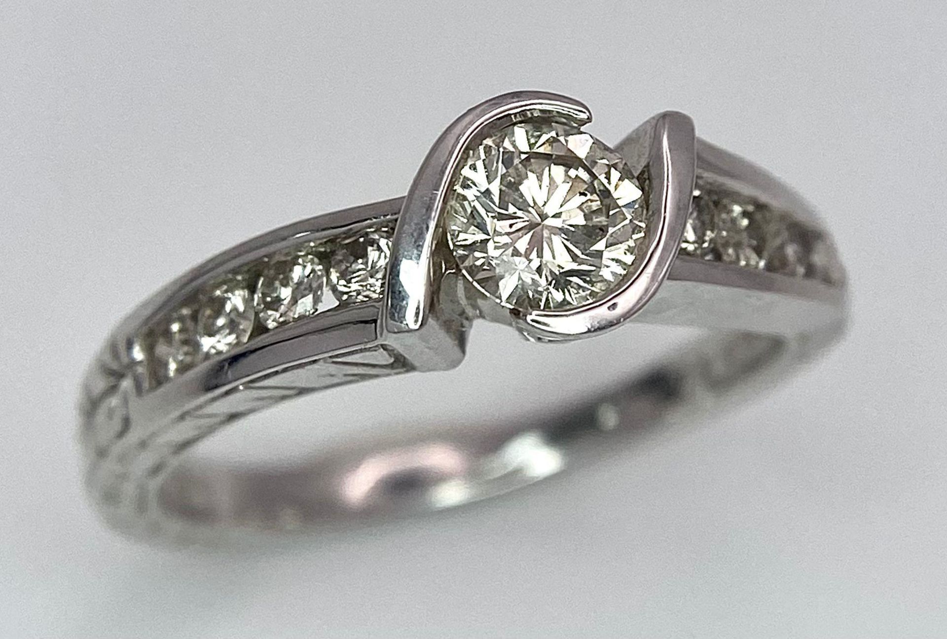 An 18K White Gold Diamond Crossover Ring. 0.50ct tinted brilliant round cut diamond with eight round - Image 3 of 9