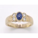 An 18K Yellow Gold (tested) Sapphire and Diamond Ring. Central oval sapphire with two bright