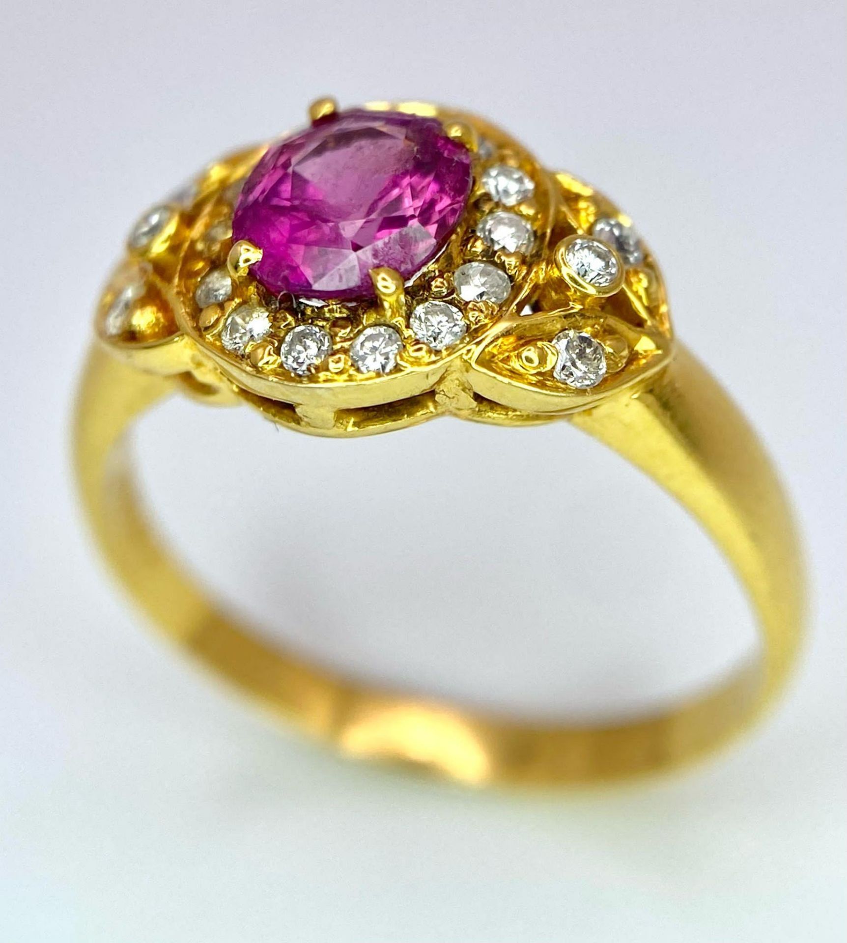 An 18K Yellow Gold Pink Sapphire and Diamond Ring. Central oval sapphire with diamond halo and - Image 3 of 12