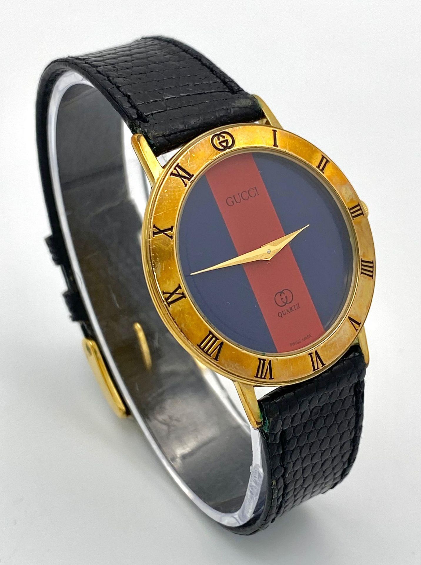 An iconic GUCCI watch with original lizard skin strap. Case: 33 mm, red/blue dial with gold coloured - Image 3 of 6