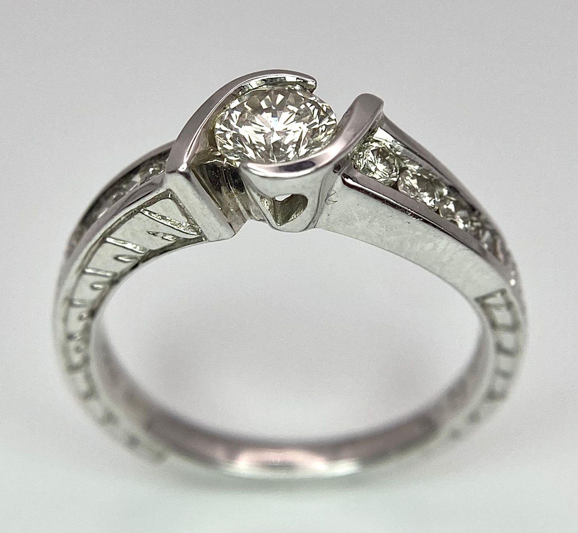 An 18K White Gold Diamond Crossover Ring. 0.50ct tinted brilliant round cut diamond with eight round - Image 4 of 9