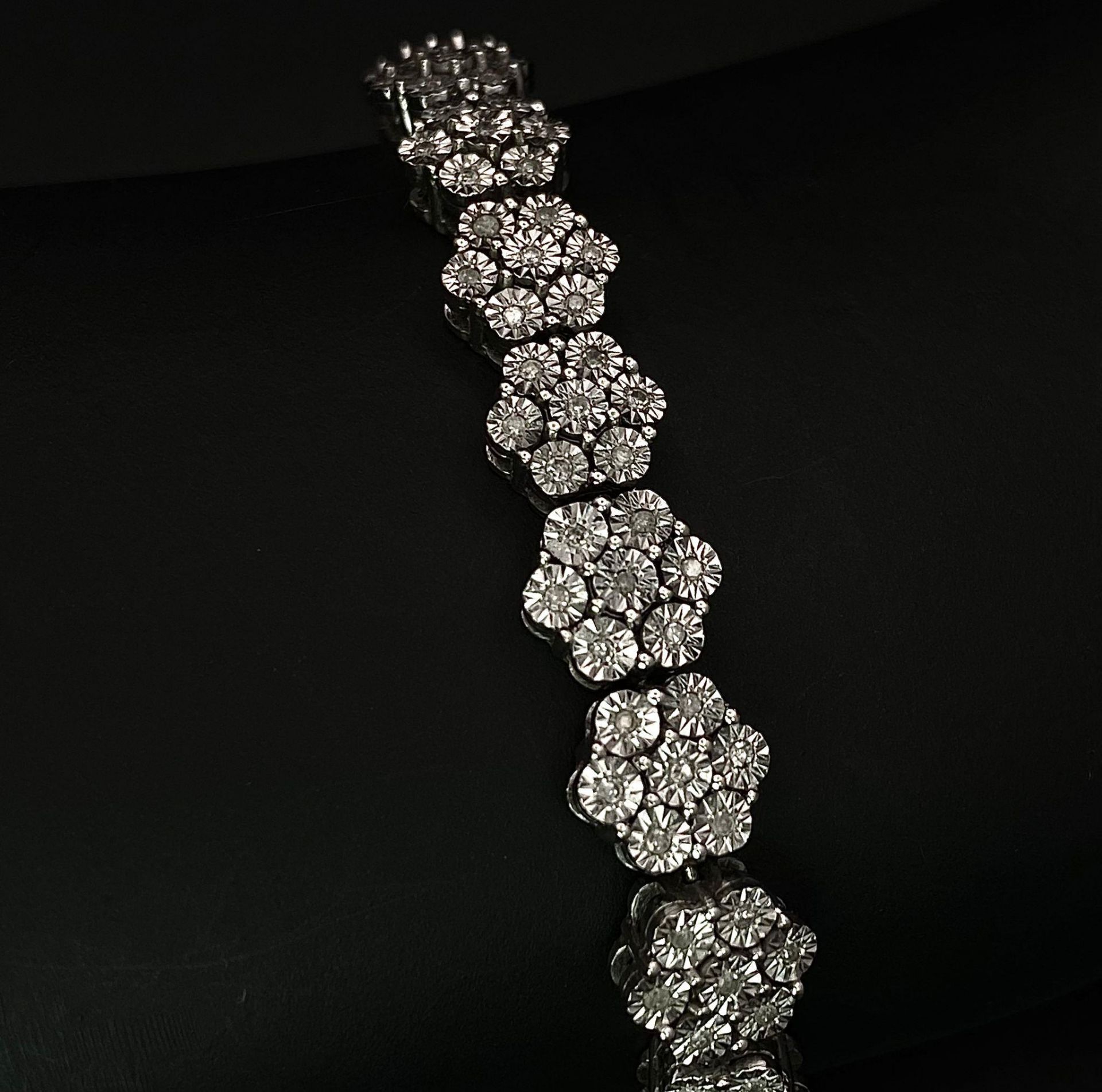 A 9K White Gold Graduated Link Diamond Tennis Bracelet. 29 links of seven small diamonds - 203