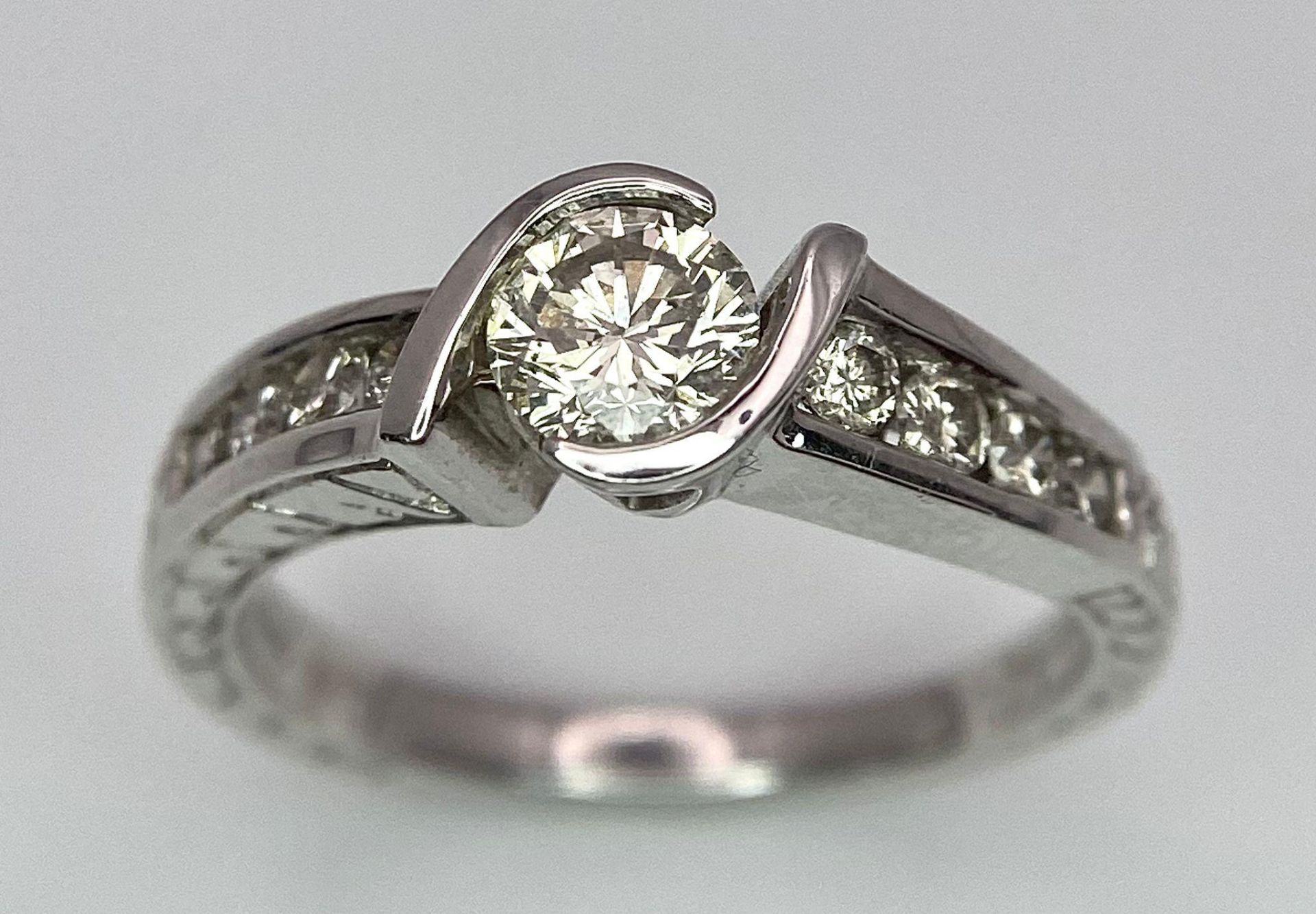 An 18K White Gold Diamond Crossover Ring. 0.50ct tinted brilliant round cut diamond with eight round - Image 2 of 9