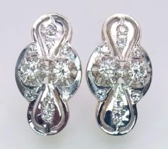 An 18 K white and yellow gold pair of earrings with a nice, diamond set design, length: 21 mm,