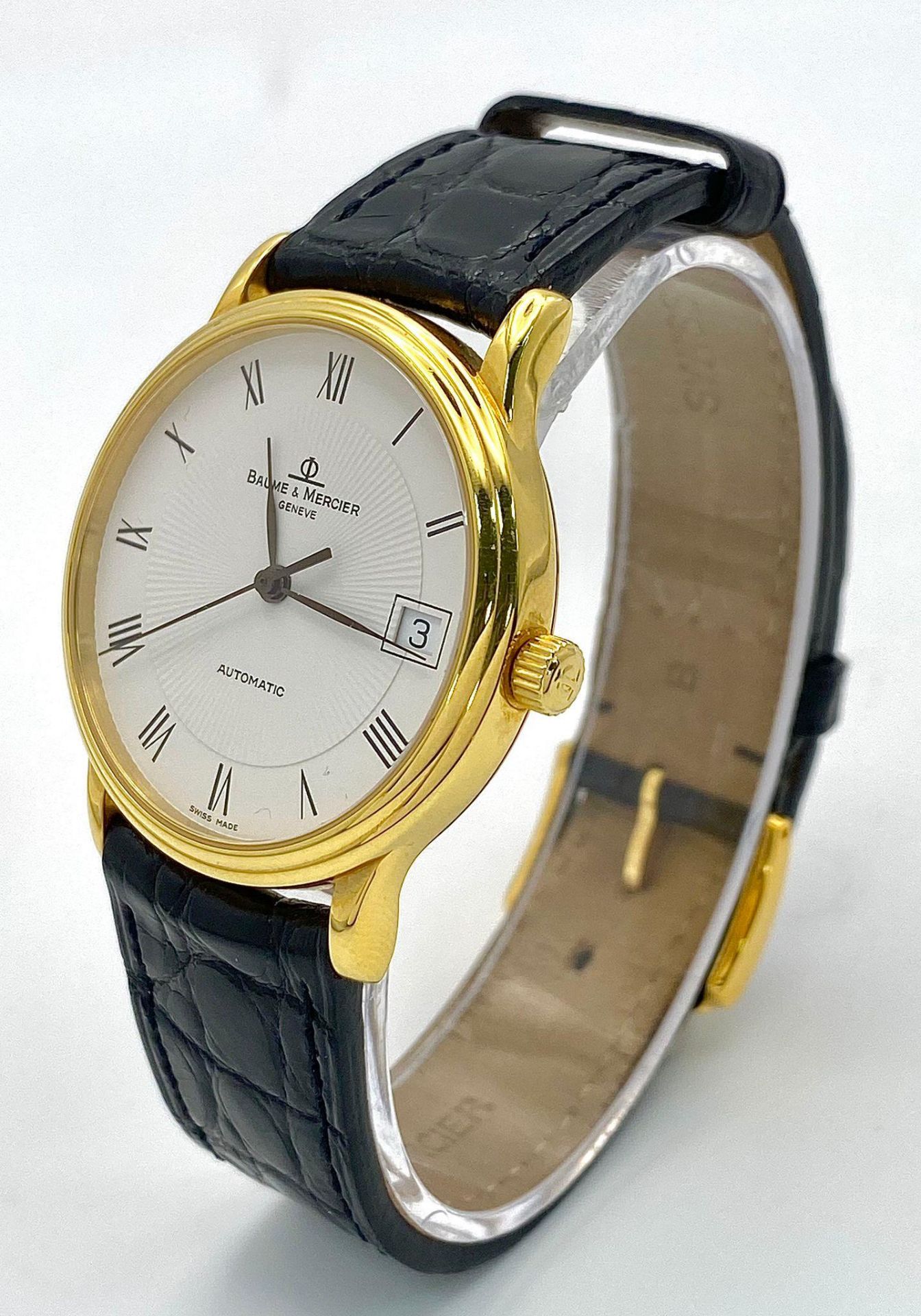 A Baume and Mercier 18K Gold Cased Automatic Gents Watch. Model - MV045075. Black leather strap. 18k