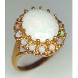 A VERY ATTRACTIVE 9K GOLD AUSRALIAN OPAL RING SURROUNDED BY COLORE PLAY OPALS . 4.8gms size P
