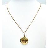 A 9 K yellow gold locket with two loving birds sitting on a branch engraved on the front. With a