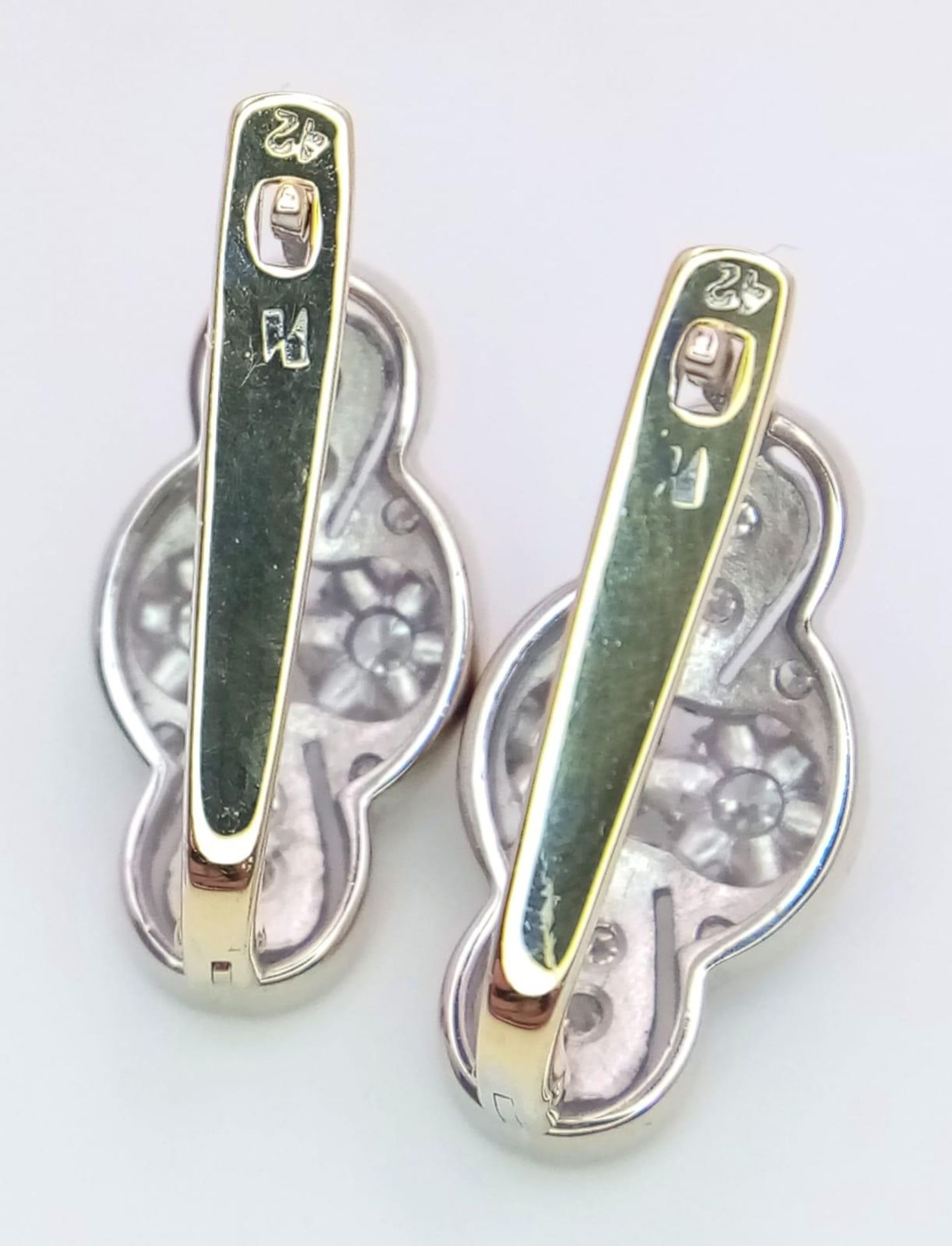 An 18 K white and yellow gold pair of earrings with a nice, diamond set design, length: 21 mm, - Bild 3 aus 6