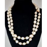 A very desirable, two strand white, natural pearl necklace in an unusual design, adorned with a 9
