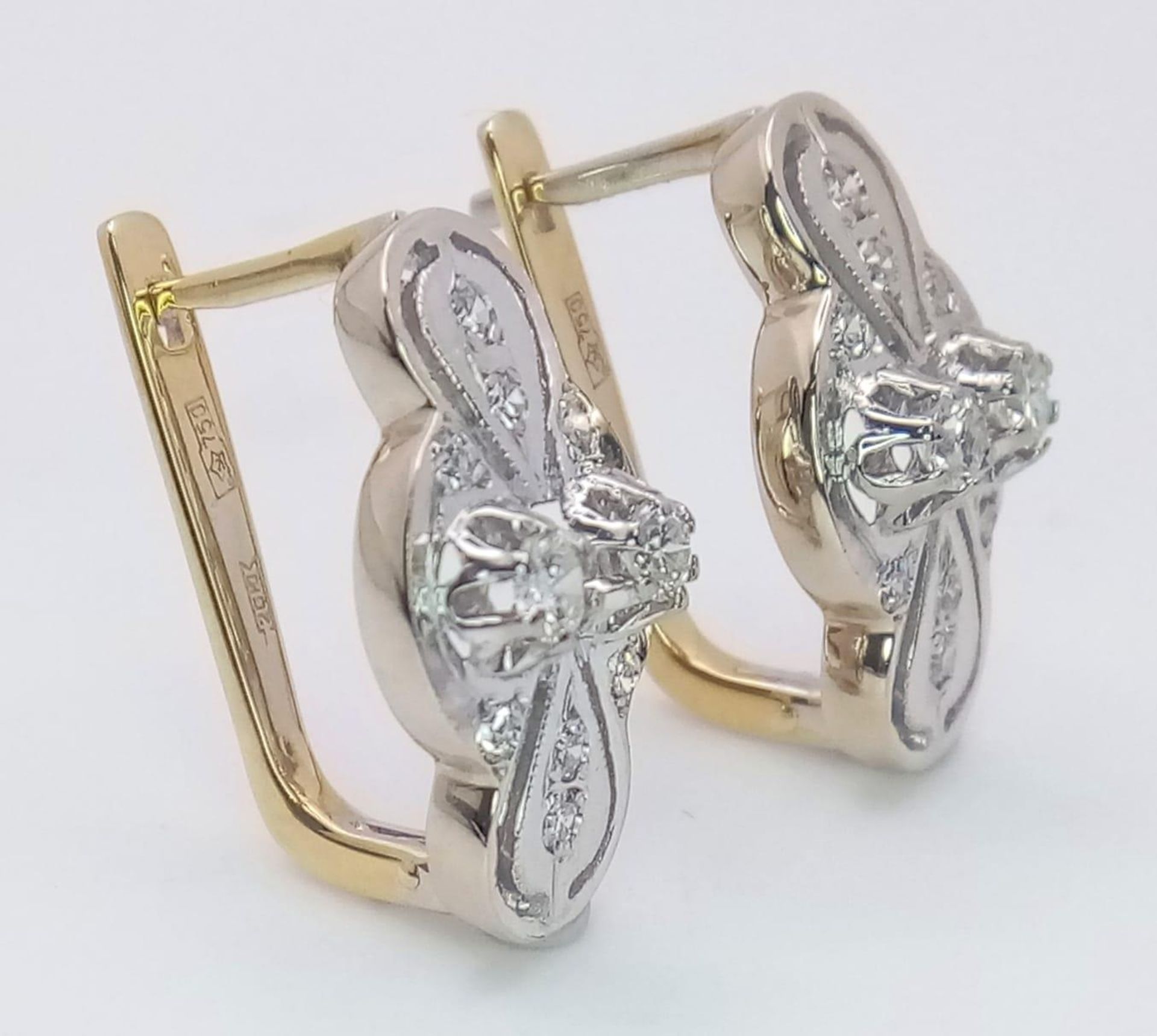 An 18 K white and yellow gold pair of earrings with a nice, diamond set design, length: 21 mm, - Bild 2 aus 6