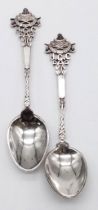 A pair of antique sterling silver tea spoons with tremendous engravings. Full hallmarks