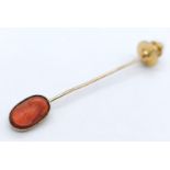 A Victorian Red Coral and Mid-Karat Gold Stickpin. A carved red coral cameo of a Greek/Roman