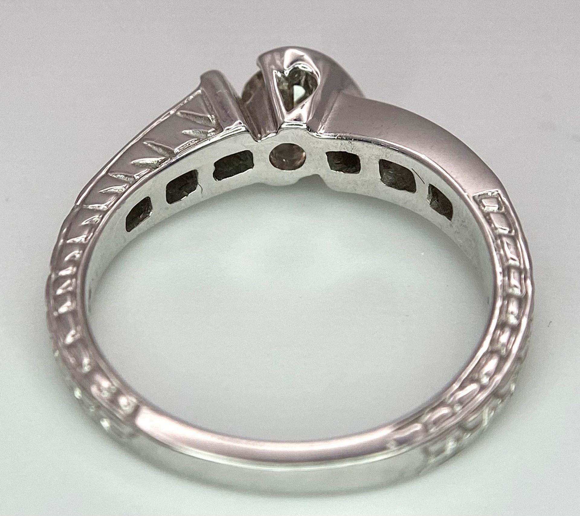 An 18K White Gold Diamond Crossover Ring. 0.50ct tinted brilliant round cut diamond with eight round - Image 7 of 9