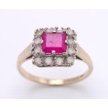 A vintage 9 K yellow gold ring with a square emerald cut ruby surrounded by a halo of white