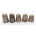 A collection of 5 antique thimbles with multiple sizes and different designs. Some of them come with