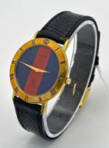 An iconic GUCCI watch with original lizard skin strap. Case: 33 mm, red/blue dial with gold coloured
