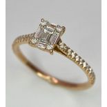An 18 K rose gold ring with a square emerald cut diamond and more round cut diamonds on the
