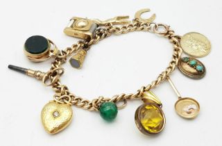 A Vintage 9K Yellow Gold Charm Bracelet. Includes: Diamond heart, carnelian fob and St