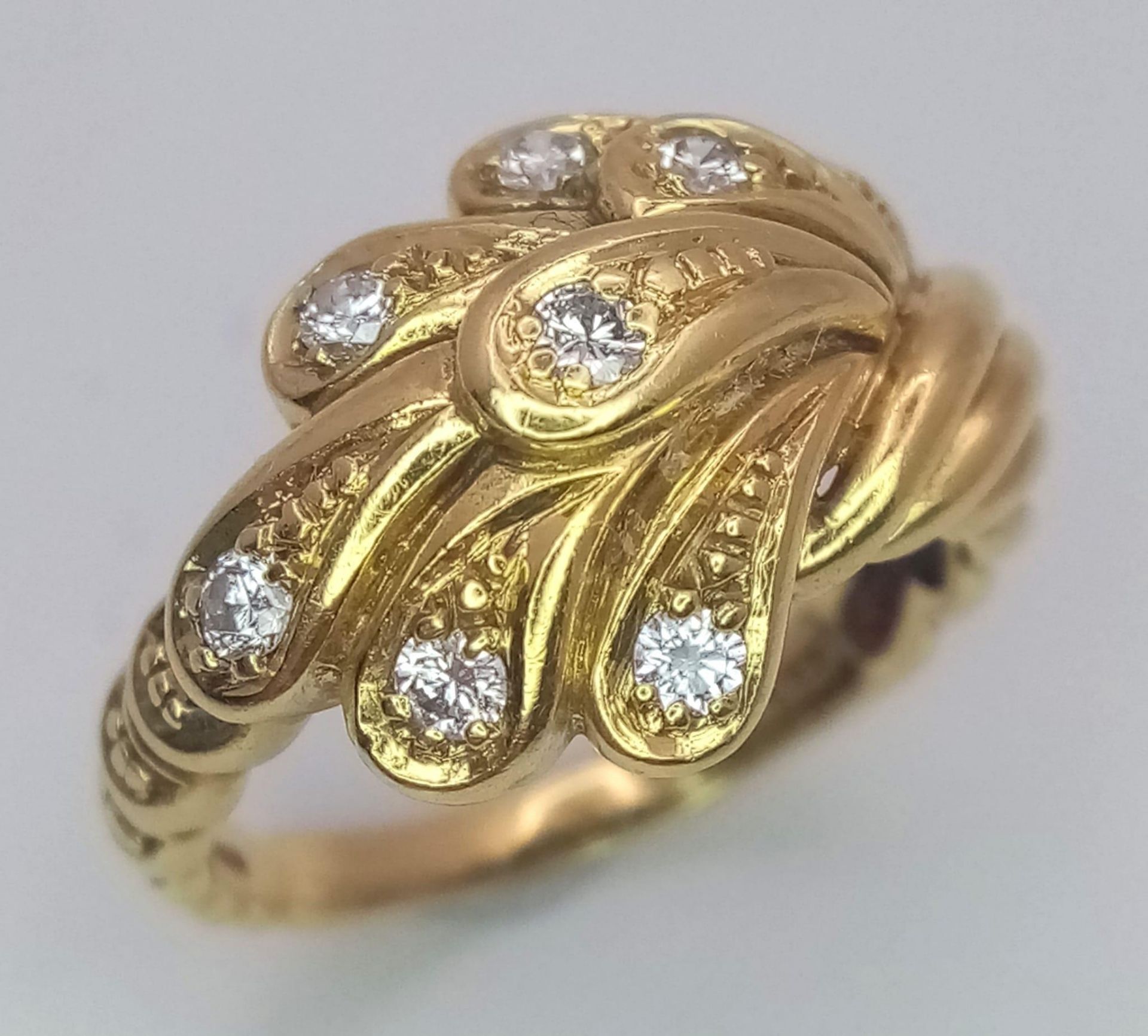 An 18 K yellow gold ring with an unusual design and eight good quality round cut diamonds. Size: