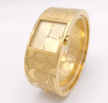 A CLIP BANGLE FASHION WATCH BY COACH , WITH QUARTZ MOVEMENT AND SQUARE GOLD TONE DIAL . COMES WITH