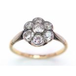 A Vintage 18K Yellow Gold Diamond Ring. Seven round cut diamonds in a floral shape. Size P. 2.52g