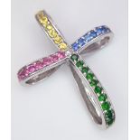 A highly unusual 14 K white gold cross studded with emeralds, rubies citrine and sapphires.